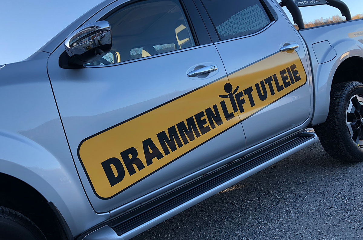 Nærbilde av logo på en bil for Drammen Liftutleie